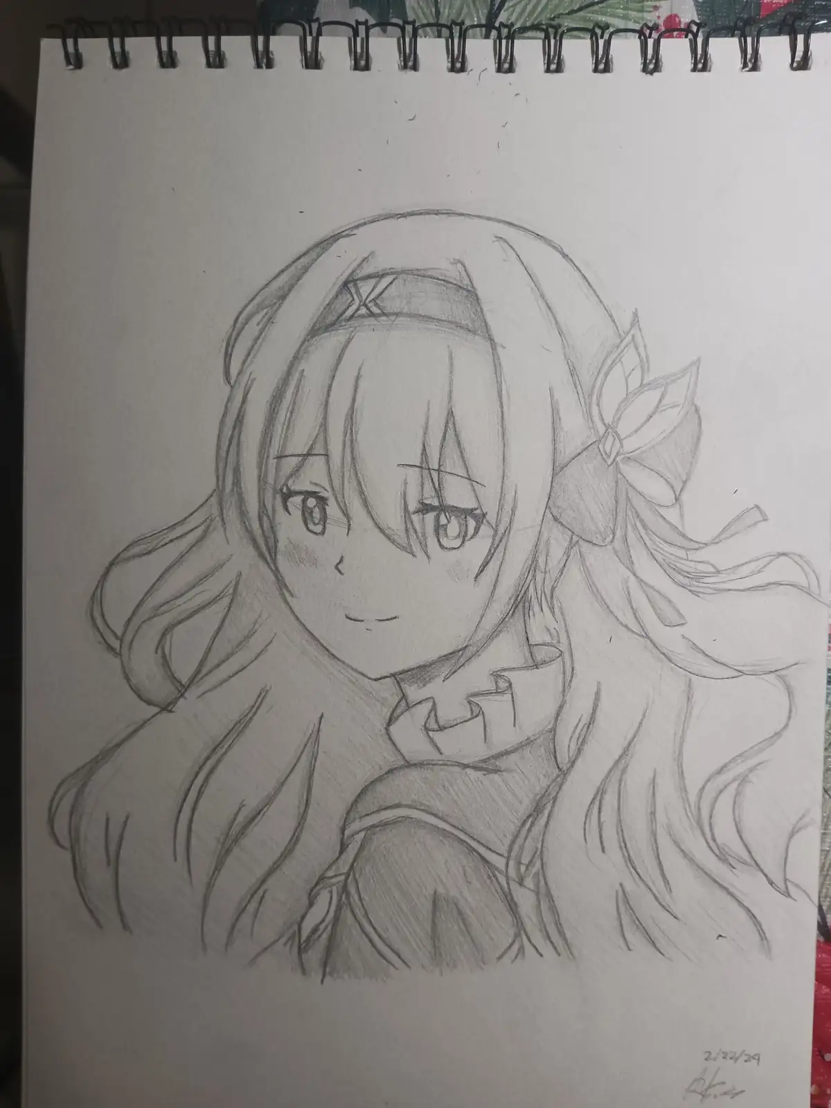A pencil sketch on a spiral-bound notebook page shows an anime-style girl with long hair, a headband, and a bow, wearing a…
