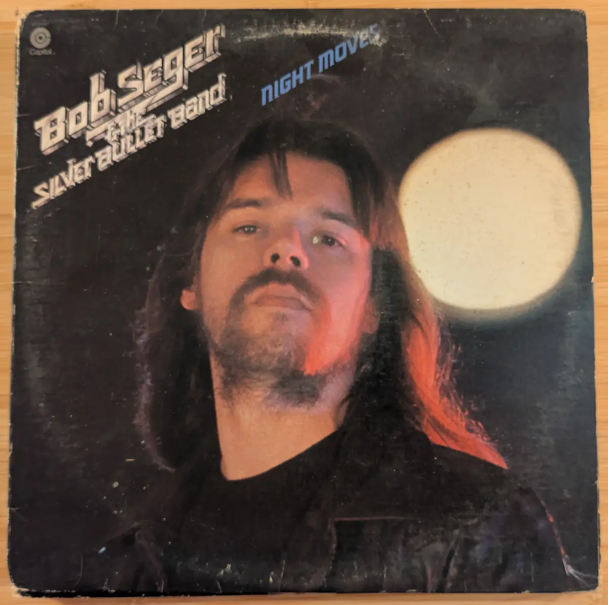 The image shows the cover of Bob Seger & The Silver Bullet Band's 1976 album 'Night Moves,' featuring a close-up of Seger…