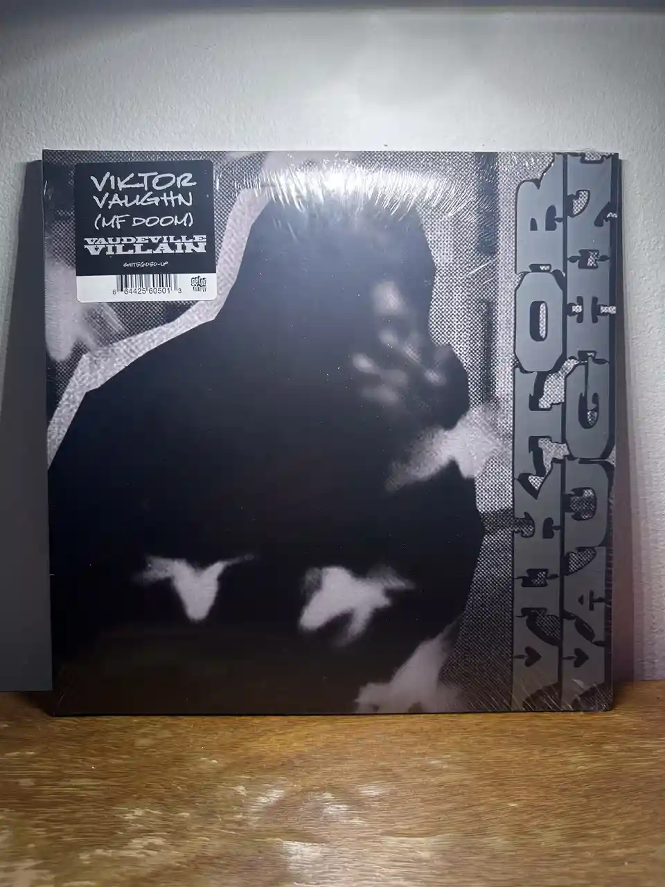A black-and-white album cover of MF DOOM's 'Vaudeville Villain' is shown, with a sticker on the top left that reads 'VIKTOR…