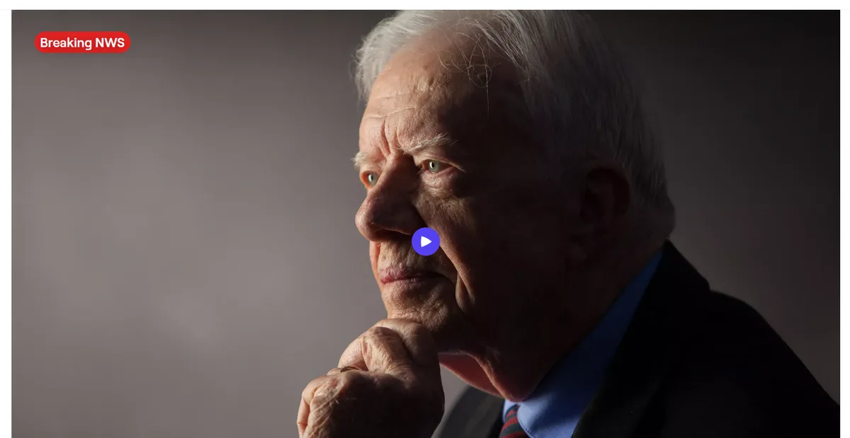 A close-up profile photo of an elderly man with white hair, wearing a suit and tie, looking thoughtfully to the side with…