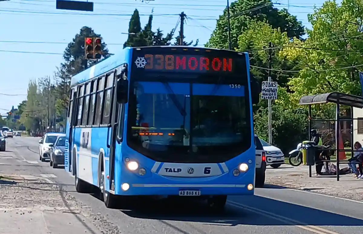 A blue and white public bus with route number 338MORON displayed on its front digital sign, which also shows a snowflake…
