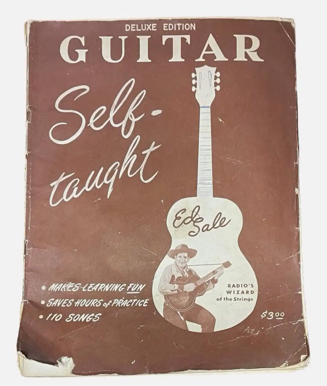 A vintage brown guitar instruction book cover titled 'Guitar Self-Taught Deluxe Edition' by Ed Sale, featuring a white…