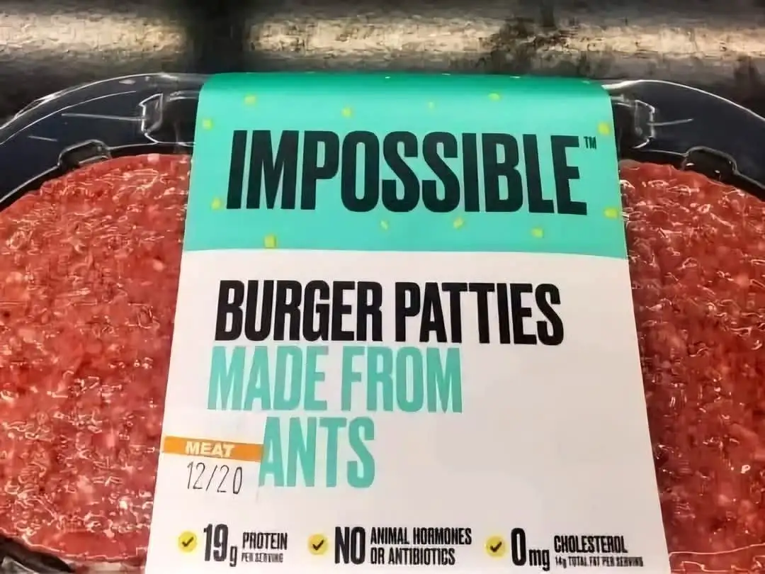 A close-up of an Impossible Burger patty package with a handwritten note that reads 'MEAT 12/20' and the text 'IMPOSSIBLE…