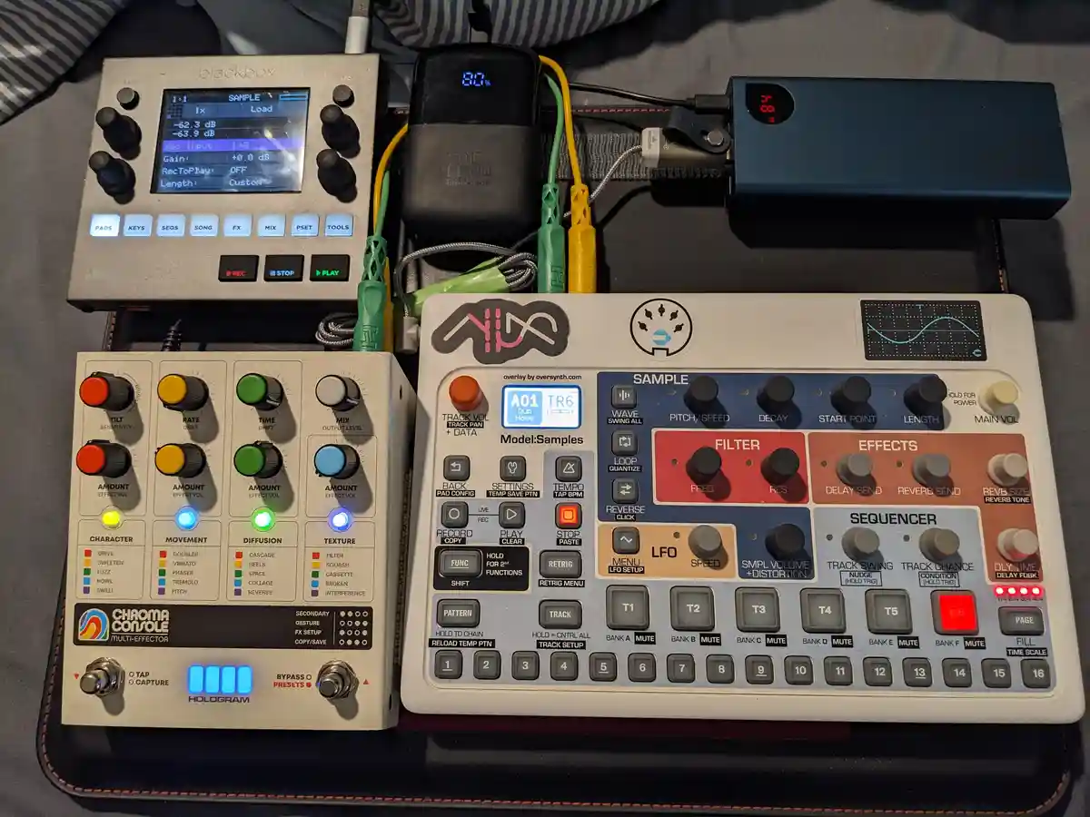 An overhead shot of three electronic music devices — a blackbox sampler, a Chroma Console multi-effector, and a NUX sample…