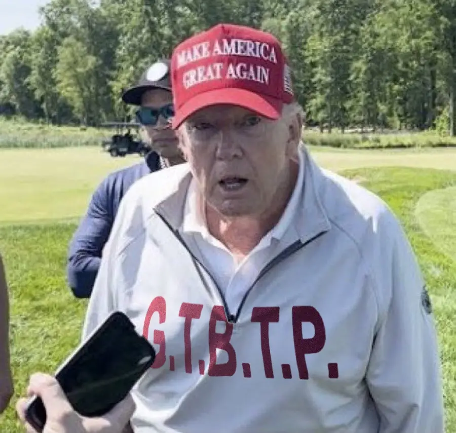 A man wearing a red 'Make America Great Again' cap and a light-colored jacket stands outdoors on a golf course, holding a…