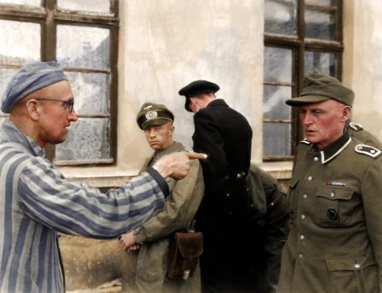 A historical photograph shows a man in a striped prisoner uniform pointing accusingly at a man in a Nazi uniform. Another…
