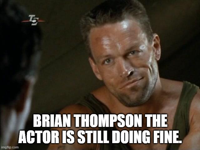 A close-up of actor Brian Thompson in a green tank top, looking intensely at someone off-screen with a slight smirk. The…