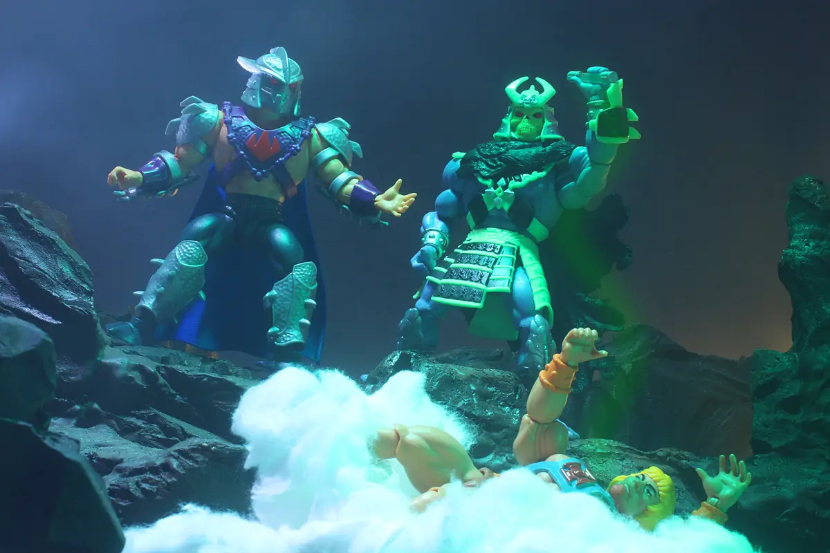 Two villainous action figures, one in purple armor and one in green samurai armor, stand over a third figure lying in a pile…