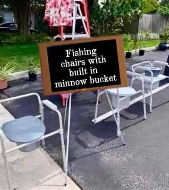 An outdoor scene shows two white metal folding chairs with built-in buckets underneath, placed on a paved surface. A black…
