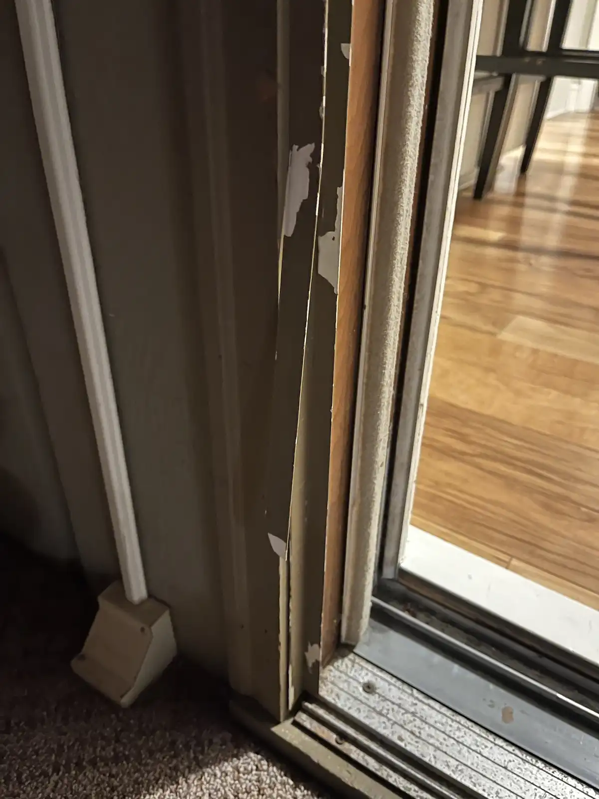 A close-up photo shows a worn, peeling door frame with visible damage and a carpeted floor, with overlaid text reading 'i'm…