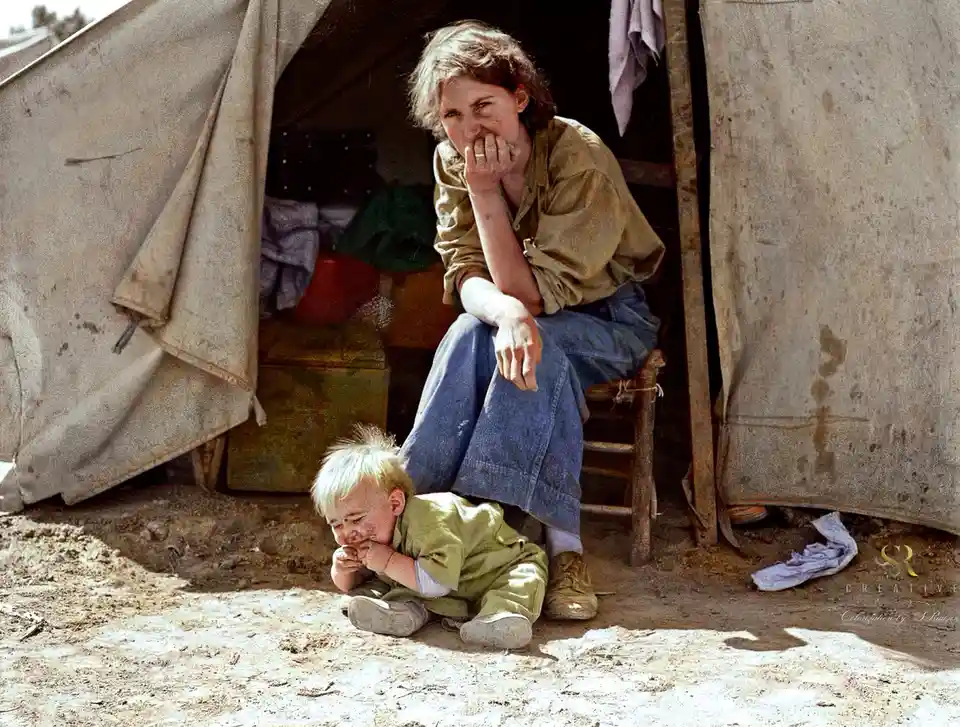 A historical photo shows a young girl sitting on a stool outside a worn tent, looking distressed with her hand over her…