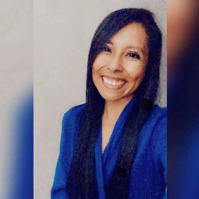 A smiling woman with long dark hair wearing a blue top and scarf, with the text 'i'm not a fan of this' overlaid. The image…