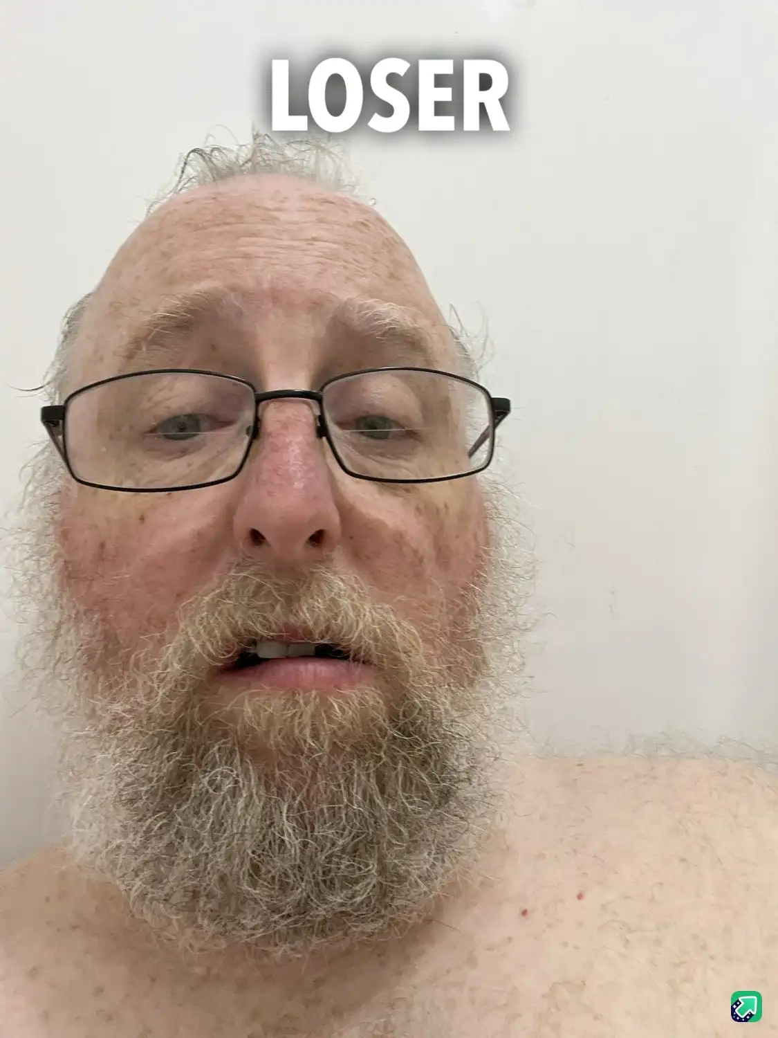 A close-up photo of a middle-aged man with a full gray beard, glasses, and receding hairline, looking directly at the camera…