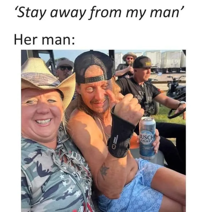 A woman in a cowboy hat smiles beside a shirtless man wearing a backward cap and a wrist brace, holding a Busch Light beer…