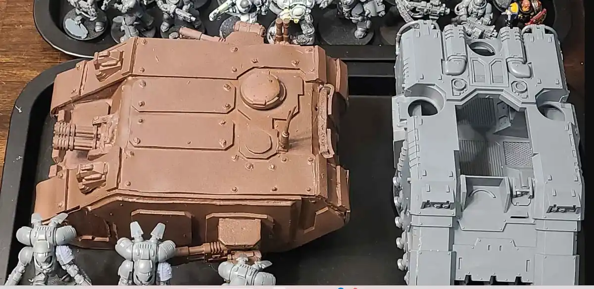 A side-by-side comparison of a painted miniature tank model on the left, showing a brownish-tan base coat, next to an…