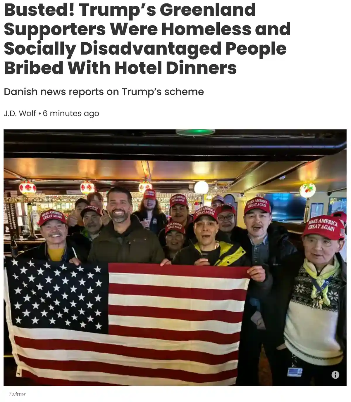 A group of people, many wearing red 'Make America Great Again' hats, pose together indoors holding a large American flag…