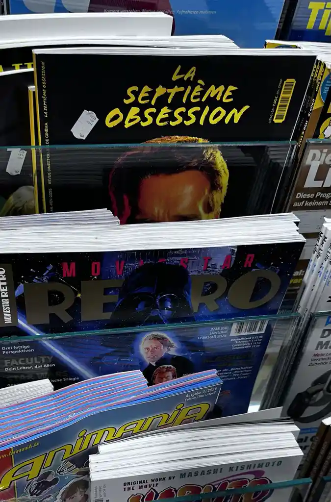 A close-up shot of a magazine shelf displaying several movie and anime magazines, with the top magazine titled 'LA SEPTIÈME…