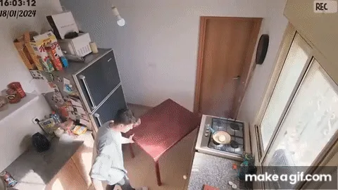 A sequence of security camera frames shows a person in a kitchen attempting to change a ceiling lightbulb. Initially, they…