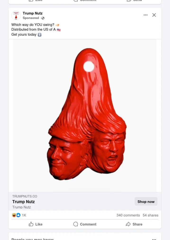 A red, glossy 3D sculpture shows two faces of Donald Trump fused together under a single pointed hat, one smiling and one…