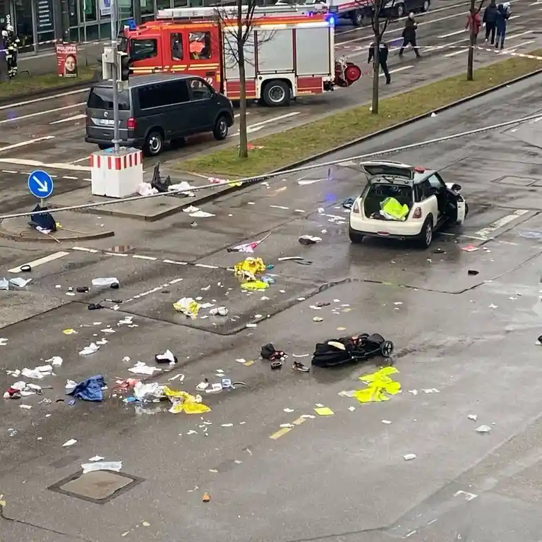 An aerial view of a chaotic street scene with a white Mini Cooper with its trunk open and doors ajar, surrounded by…