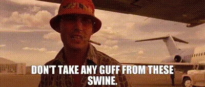 The image shows a man wearing a red bucket hat and sunglasses, standing under an airplane wing with a private jet visible in…
