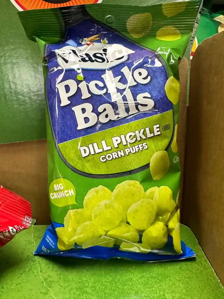 A close-up photo of a bag of 'Classic Pickle Balls' snack, labeled 'Dill Pickle Flavored Corn Puffs' with 'Big Crunch'…