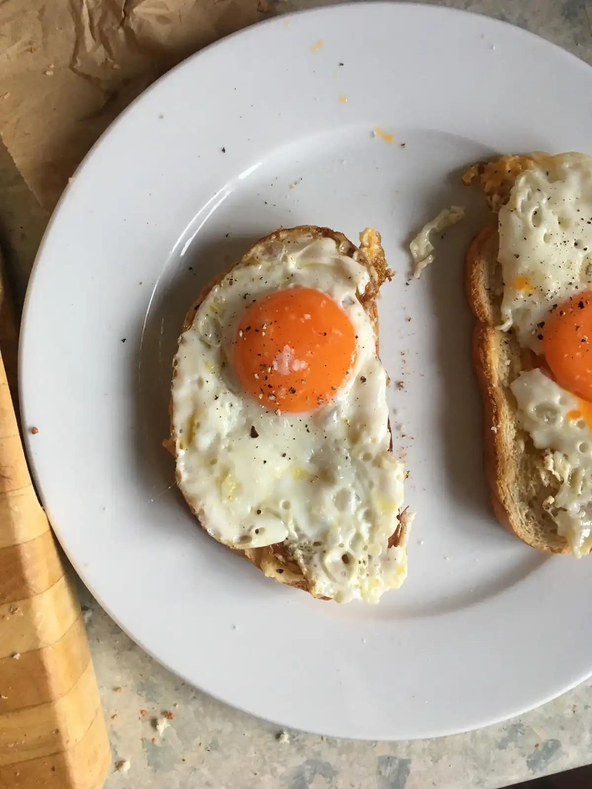 A top-down photo of two sunny-side-up eggs on toasted bread on a white plate, with the text 'i'm not lazy, i'm just resting…