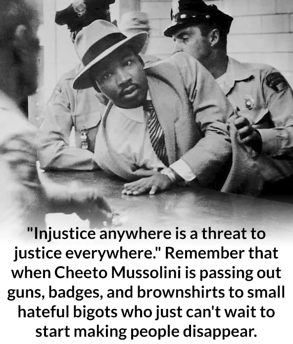 A black-and-white photo shows Martin Luther King Jr. seated at a table, flanked by two police officers in uniform. He wears…