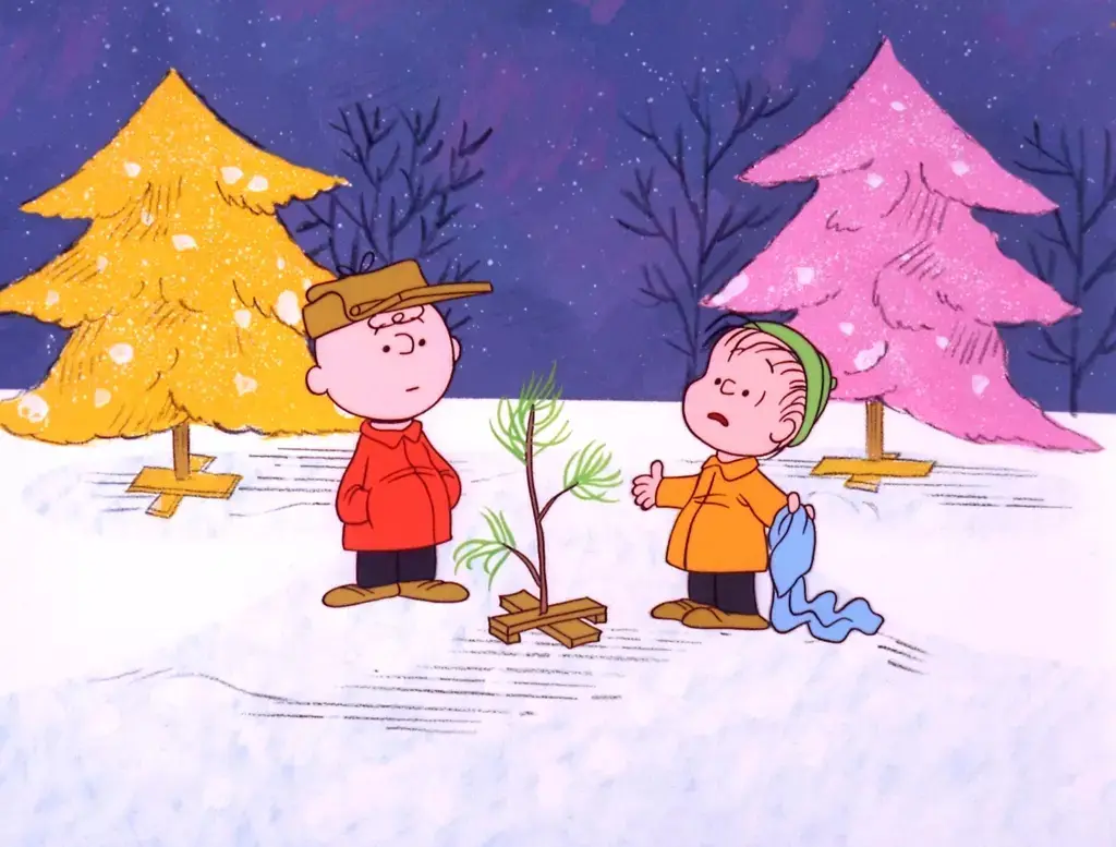 Two cartoon children stand in a snowy landscape at night, one holding a small, bare pine tree on a wooden stand while the…