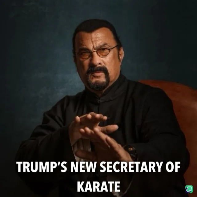 A man with glasses and a goatee, wearing a black martial arts-style shirt, sits in a chair with his hands clasped in front…