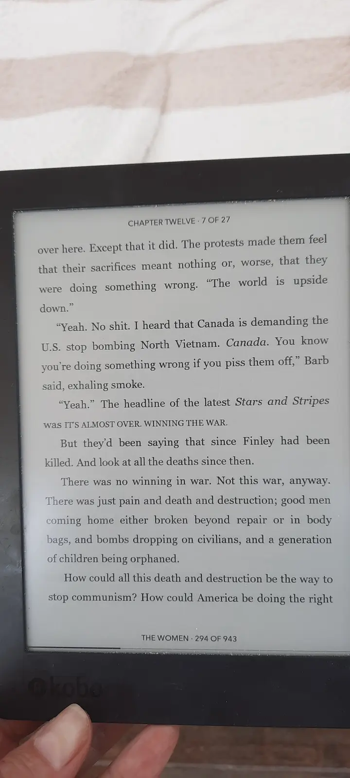 A close-up photo shows a Kobo e-reader displaying a page from the book 'The Women' by Kristin Hannah, specifically Chapter…