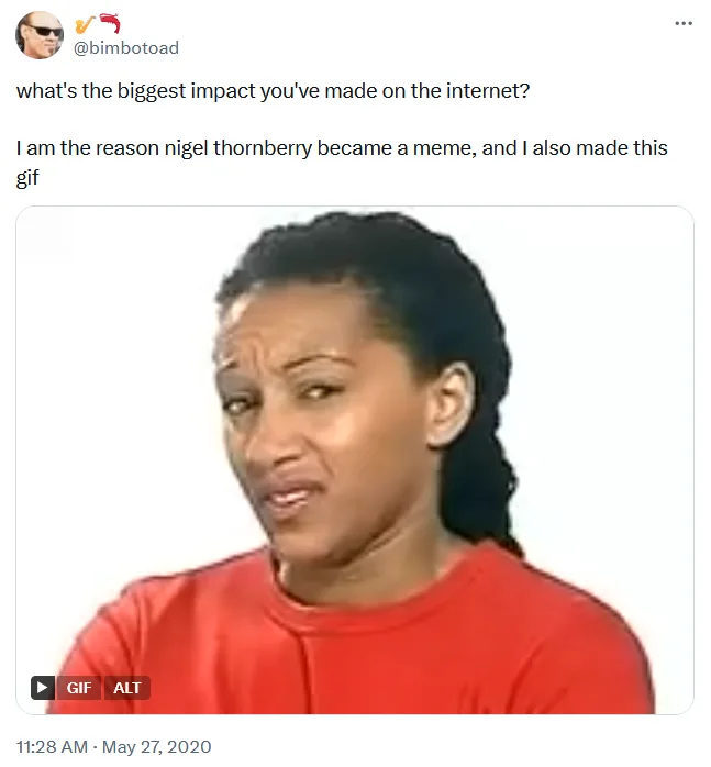 A still image from a GIF shows a woman with dark hair pulled back, wearing a red shirt, looking slightly to her right with a…