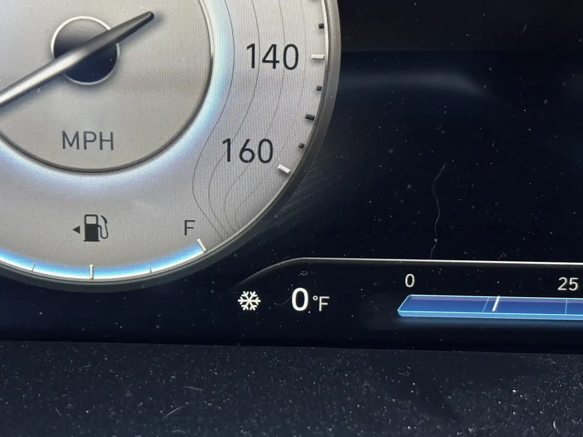 A close-up of a car's digital dashboard shows a speedometer with the needle near 0 mph, a fuel gauge at 'F' (full), and a…