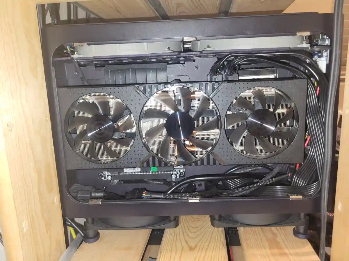 A close-up photo shows the back of a high-end graphics card with three large cooling fans, visible circuitry, and bundled…