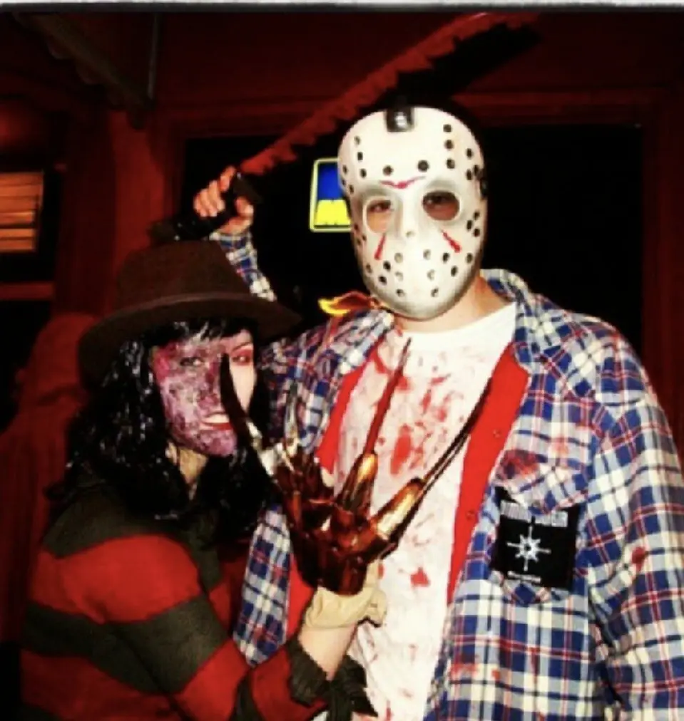 Two people dressed as horror movie villains, one as Jason Voorhees with a hockey mask and machete, the other as Freddy…