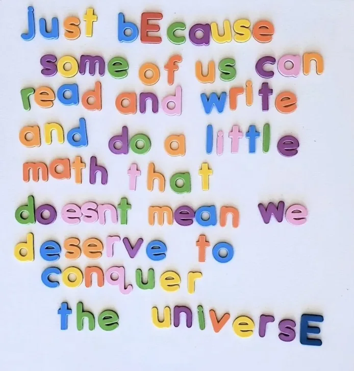 The image displays colorful magnetic letters arranged on a white surface to spell out the phrase 'just bEcause some of us…