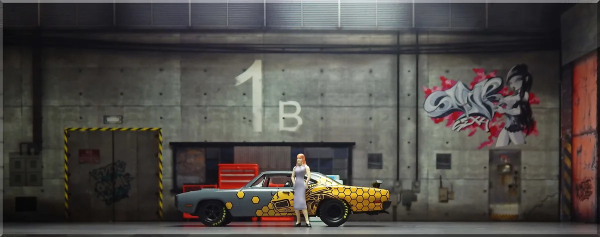A miniature model of a woman in a lavender dress stands beside a grey muscle car with a yellow honeycomb pattern. The car is…
