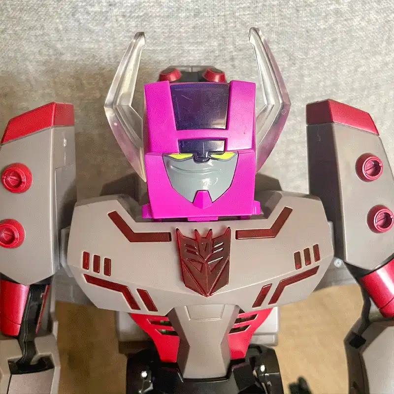 A composite image showing the same pink Transformer head mounted on three different robot bodies: one red and grey, one…