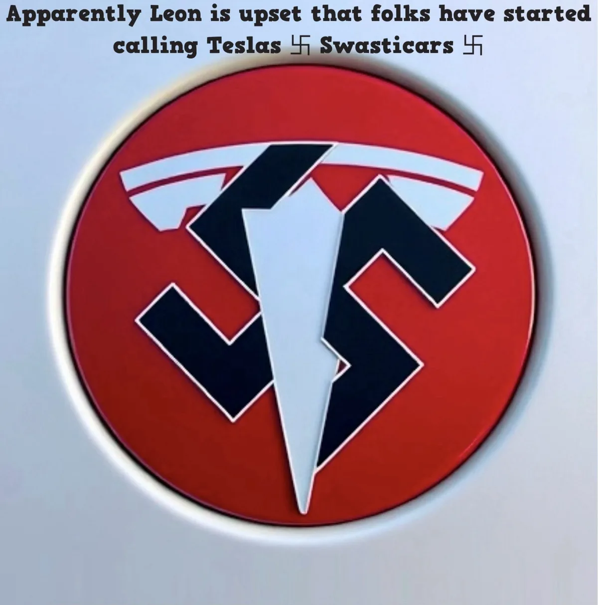 The image shows a close-up of a Tesla logo, but the iconic 'T' has been digitally altered to resemble a swastika, set…