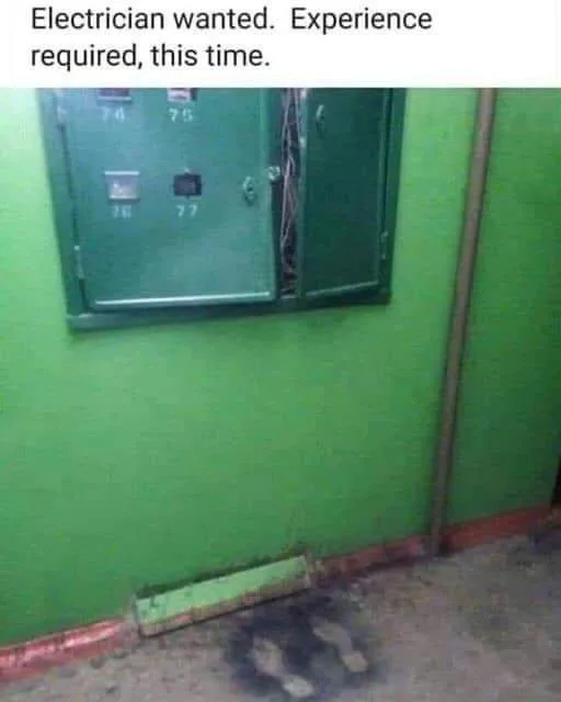 A green electrical panel is mounted on a green wall with its right door open, revealing tangled wires inside. On the floor…