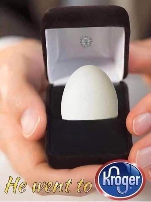 A close-up image shows two hands holding an open black velvet jewelry box. Inside the box, instead of a diamond ring, there…