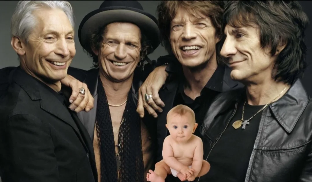 A photo of four older men, identified as The Rolling Stones, smiling and posing together with their arms around each other…