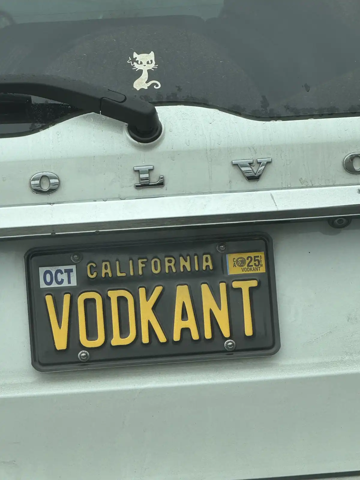 A close-up of a California license plate on a white Volvo, displaying the word 'VODKANT' in yellow letters. Above the plate…