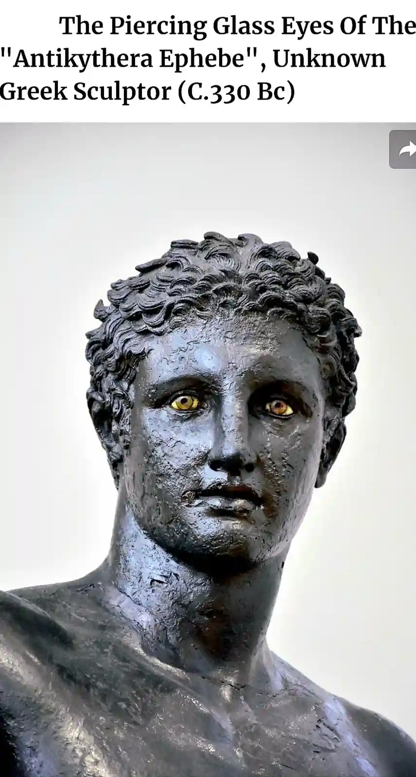A close-up of an ancient bronze statue bust, identified as the 'Antikythera Ephebe', showing a youthful male face with…