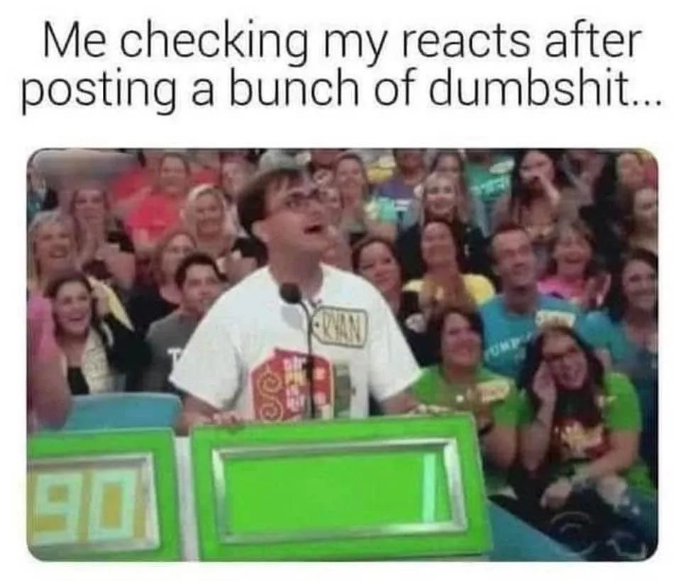 A man in a white t-shirt with glasses stands at a green game show podium, mouth open in shock, surrounded by a laughing…