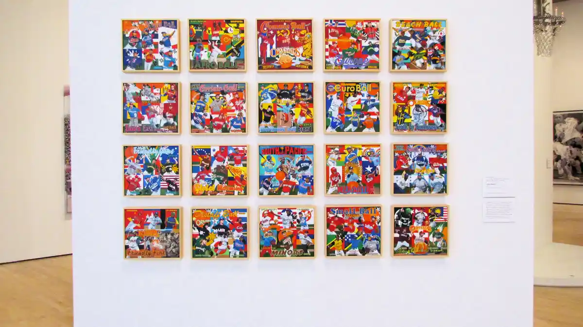 A gallery wall displays 20 framed artworks resembling vintage baseball cards, each featuring players in various uniforms and…