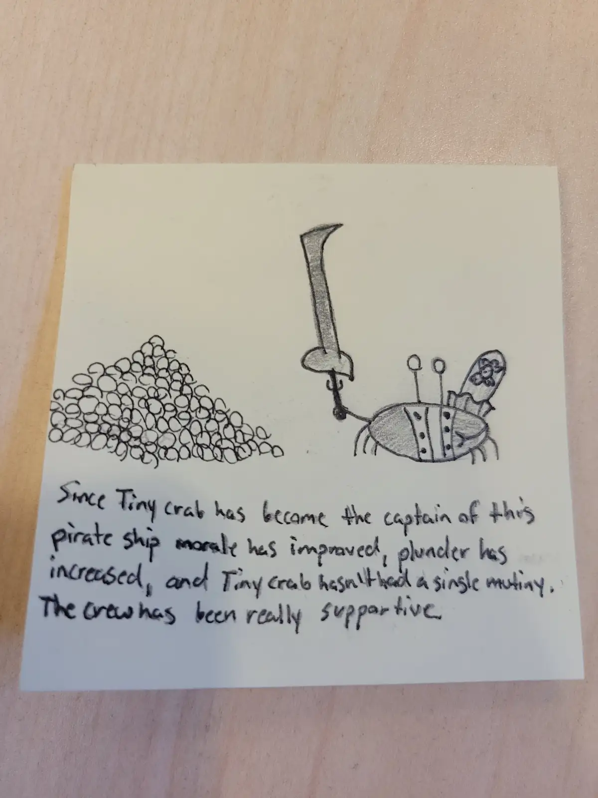 A hand-drawn sketch on a sticky note shows a cartoon crab wearing a pirate hat and holding a sword, standing next to a pile…