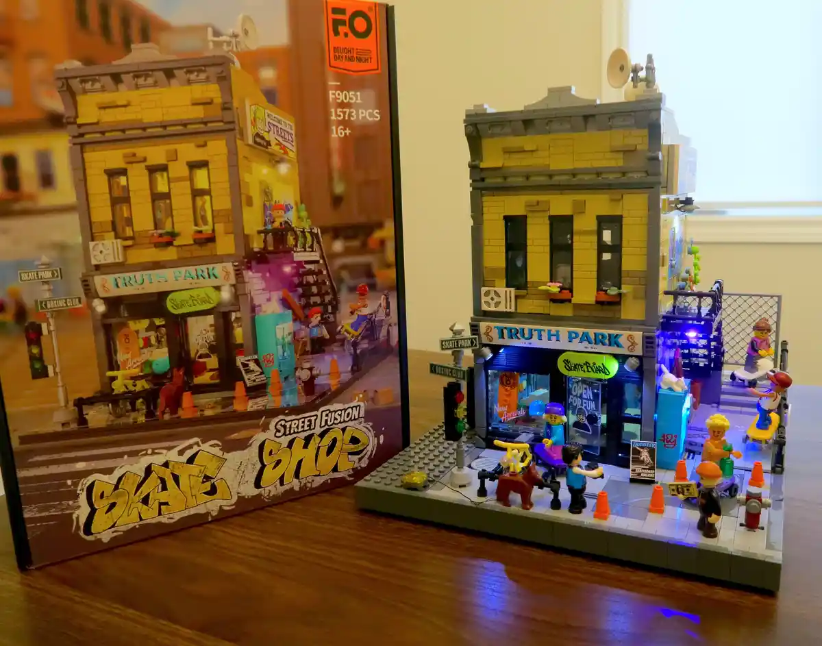 A completed 'Street Fusion Shop' model kit, branded 'Truth Park', sits next to its box on a wooden surface. The model…