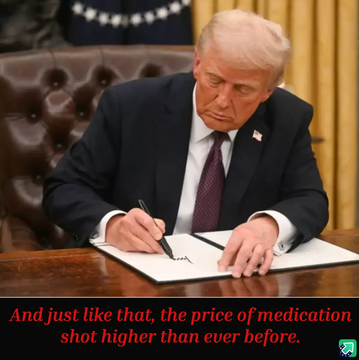 A man in a dark suit and tie is seated at a wooden desk, signing a document with a black pen. He is leaning forward with a…