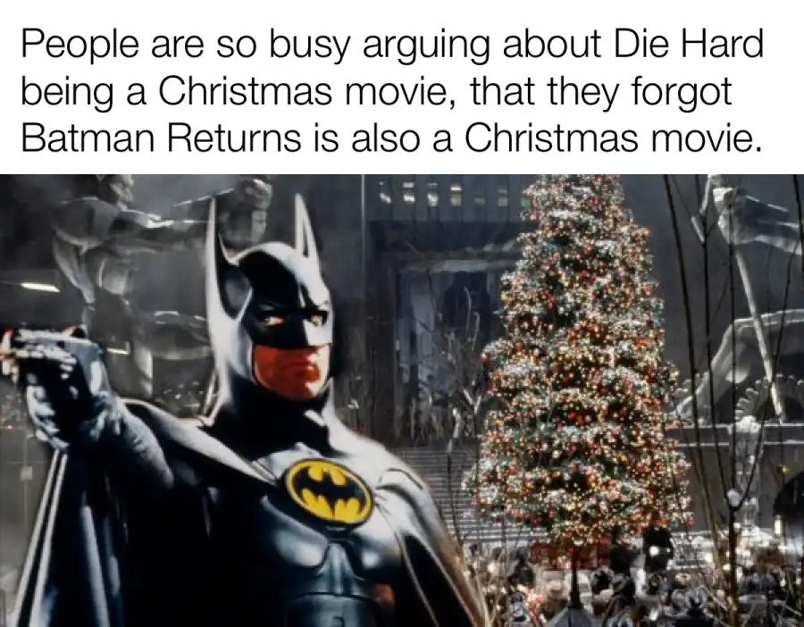 A still image from the movie 'Batman Returns' shows Batman in his iconic black suit with a yellow bat symbol, holding a gun…